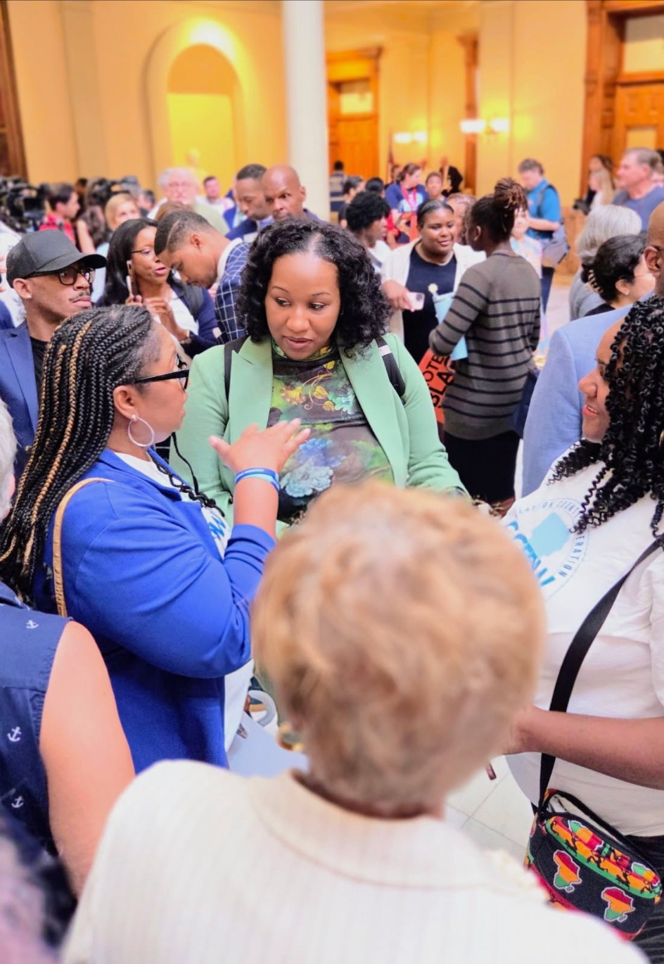 People in conversation at a crowded indoor community gathering.